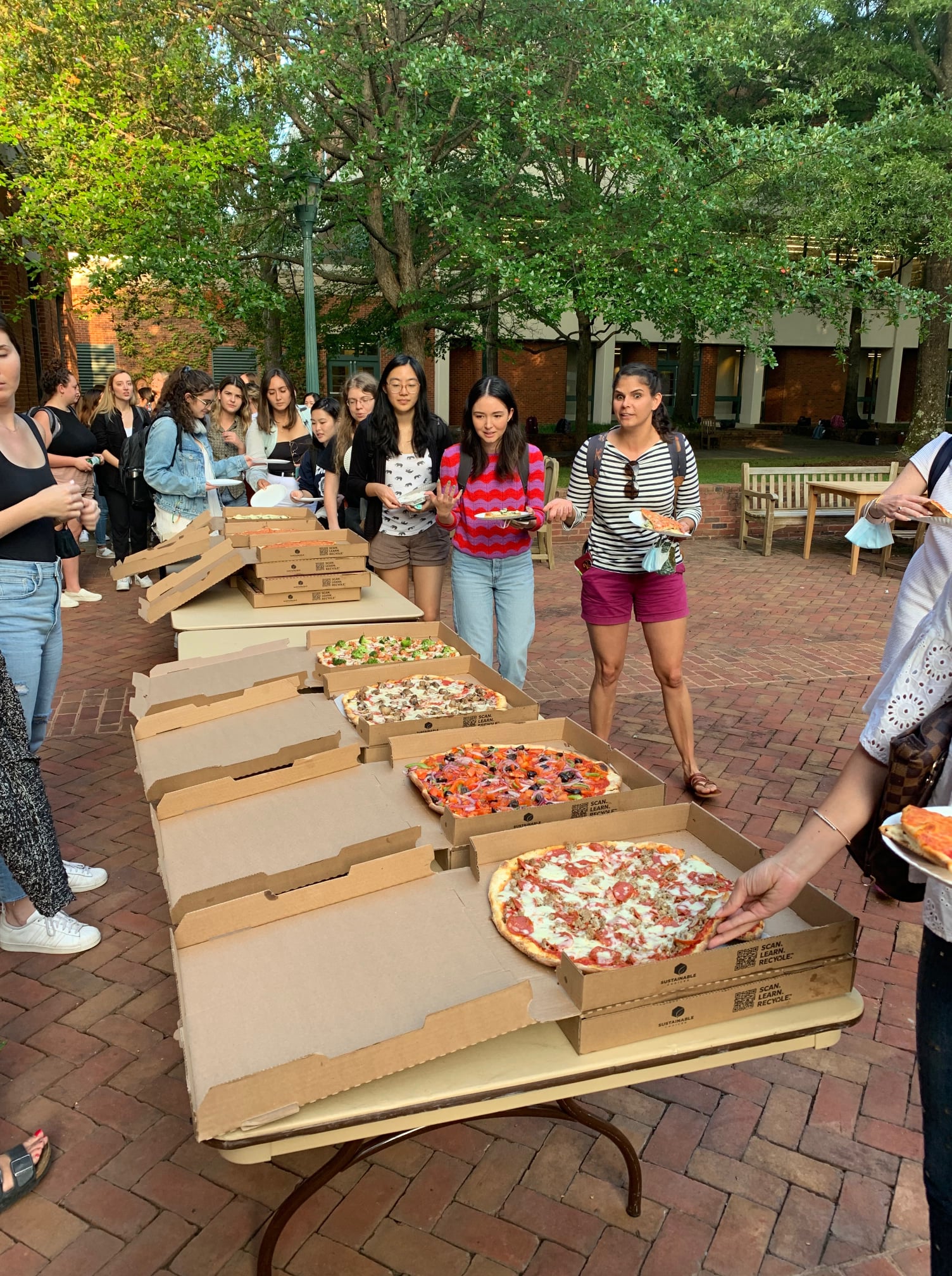 Color photograph of students lining up for pizza