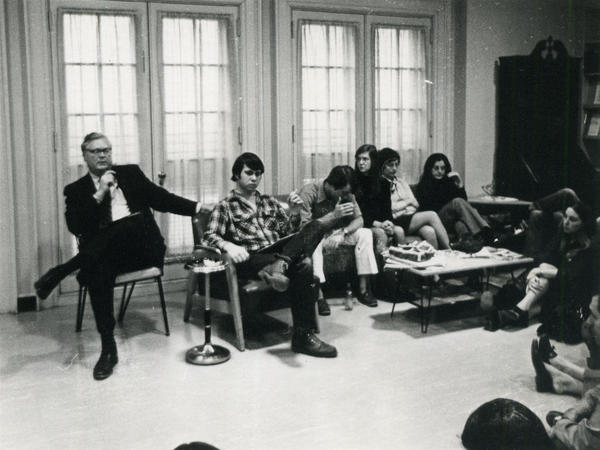 Black and white photograph of group of people sitting in lounge