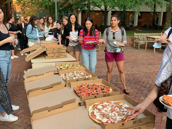 Color photograph of students lining up for pizza