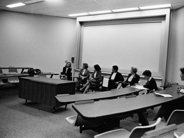 Black and white photograph of panel of female speakers in Law School classroom