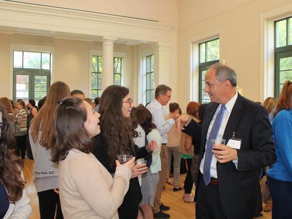 Color photograph of students and professors mingling at a reception