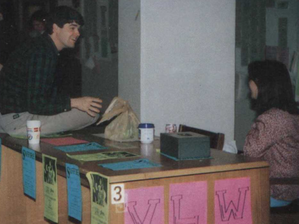 Color photograph of woman tabling and a man speaking to her